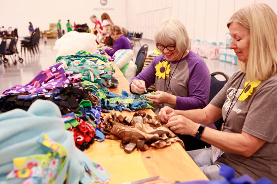 two women creating on tie blankets